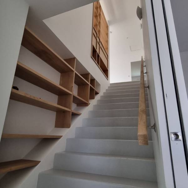 Aménagement de bibliothèque en bois massif sur mesure encastré dans un escalier à  