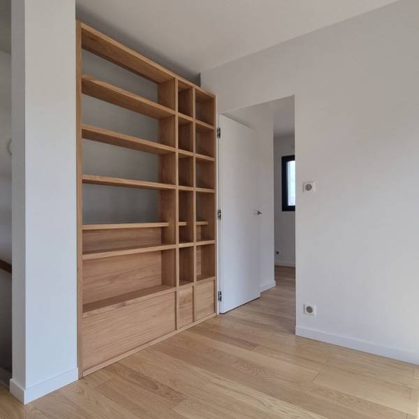 Aménagement de bibliothèque en bois massif sur mesure encastré dans un escalier à  