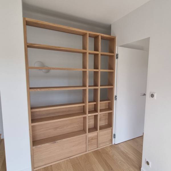 Aménagement de bibliothèque en bois massif sur mesure encastré dans un escalier à  